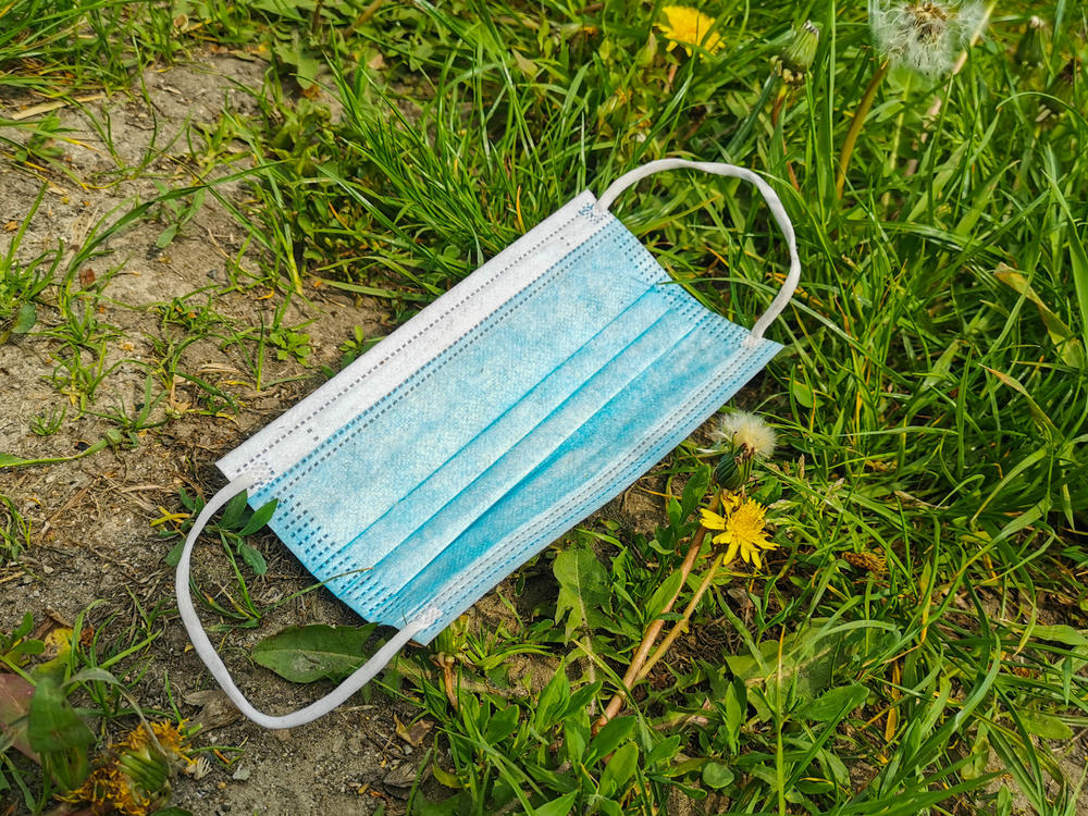 A face mask languishes in the grass in Krakow, Poland. With the state of emergency over, some people are relishing freedom from masks while others believe masking up is still a wise preventive measure.