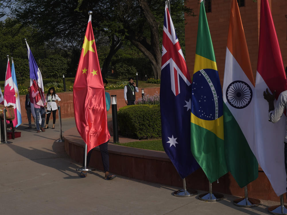 A worker carries a Chinese national flag to put it with those of other participating countries at the opening session of the G-20 foreign ministers meeting in New Delhi on March 2.