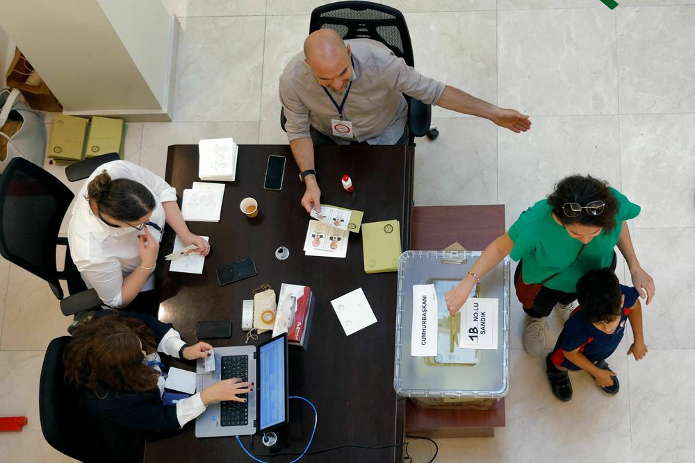 A woman casts her ballot as Turkish citizens residing in Qatar arrive to vote in the second round of Turkey's presidential election, at a polling station in the Turkish Embassy in Doha on May 21.