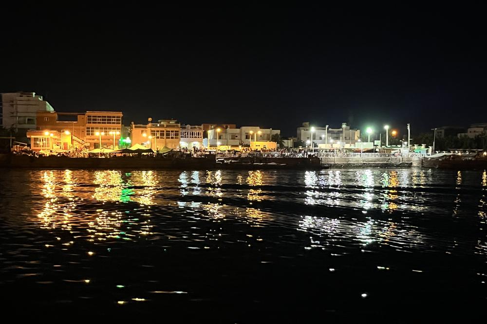 Makeshift tents and the lights from Port Sudan can be seen from a tugboat as it approaches the city, where thousands of foreigners sought refuge and evacuations. May 2, 2023.
