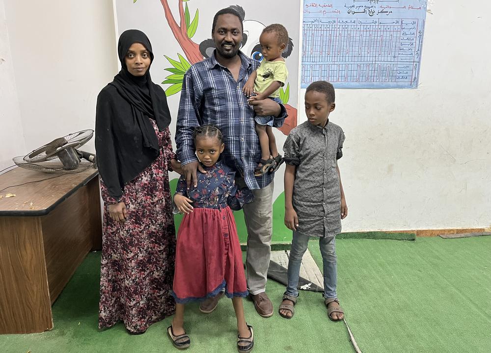 Anwar Dafala and his family stand in a Sudanese school in Cairo, where his wife and three children are sleeping until they can find accommodation. They eat meals distributed by Egyptian volunteers. May 5, 2023.