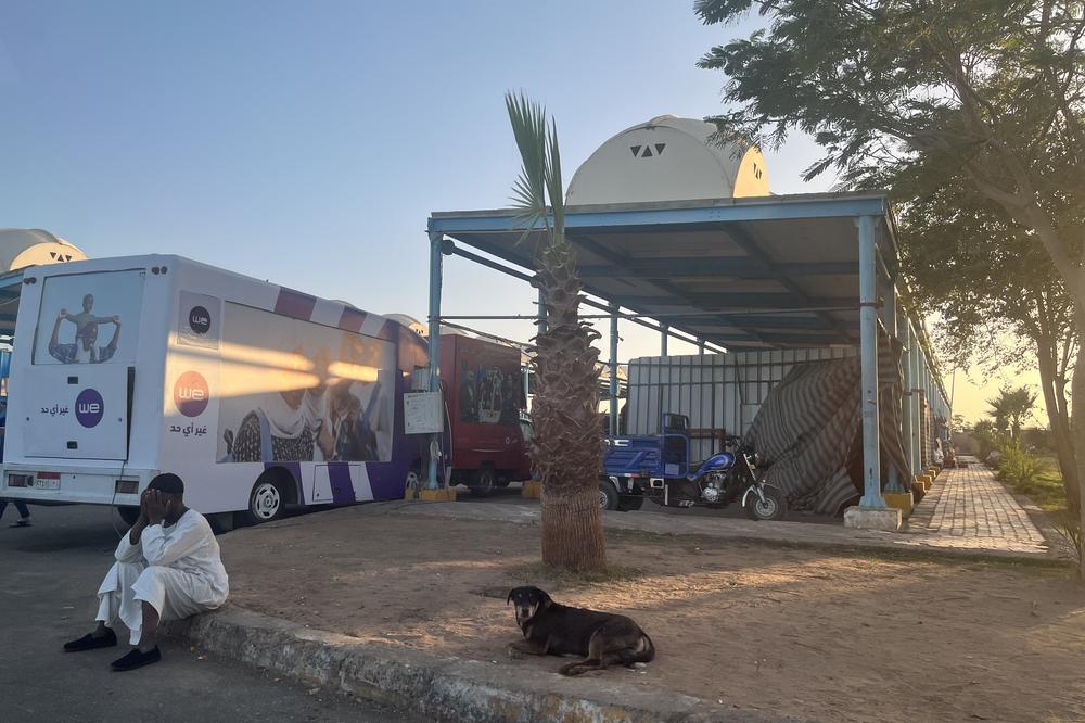 A boy rests by a mobile SIM card seller in Kar Kar, a key rest stop and bus station in Aswan for thousands of Sudanese after they've crossed into Egypt. May 7, 2023.