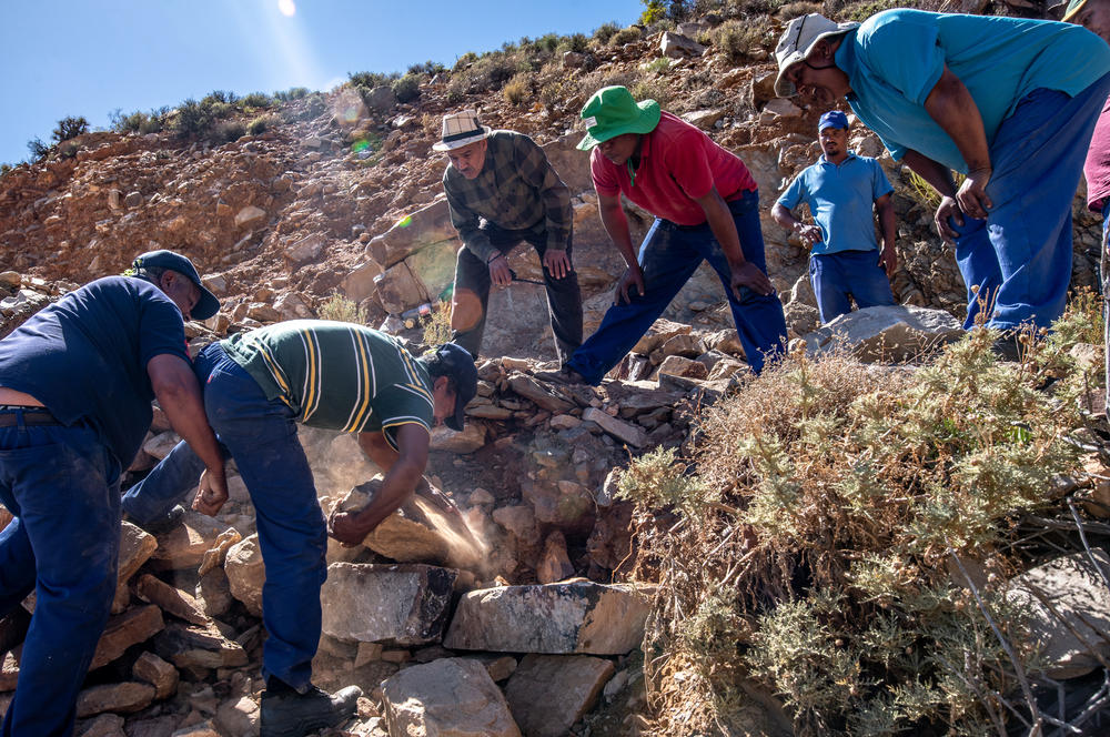 Members of an Indigenous rooibos farming co-operative repair a track to their fields in the Cederberg Mountains in South Africa. Parts of the track had been washed away by a flood a few days earlier. Farmers say such extreme weather events are becoming more frequent.