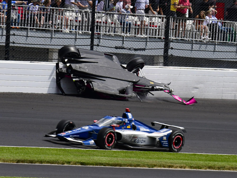 The car driven by Kyle Kirkwood, top, flips over after a crash in the second turn during the Indianapolis 500 auto race at Indianapolis Motor Speedway on Sunday.