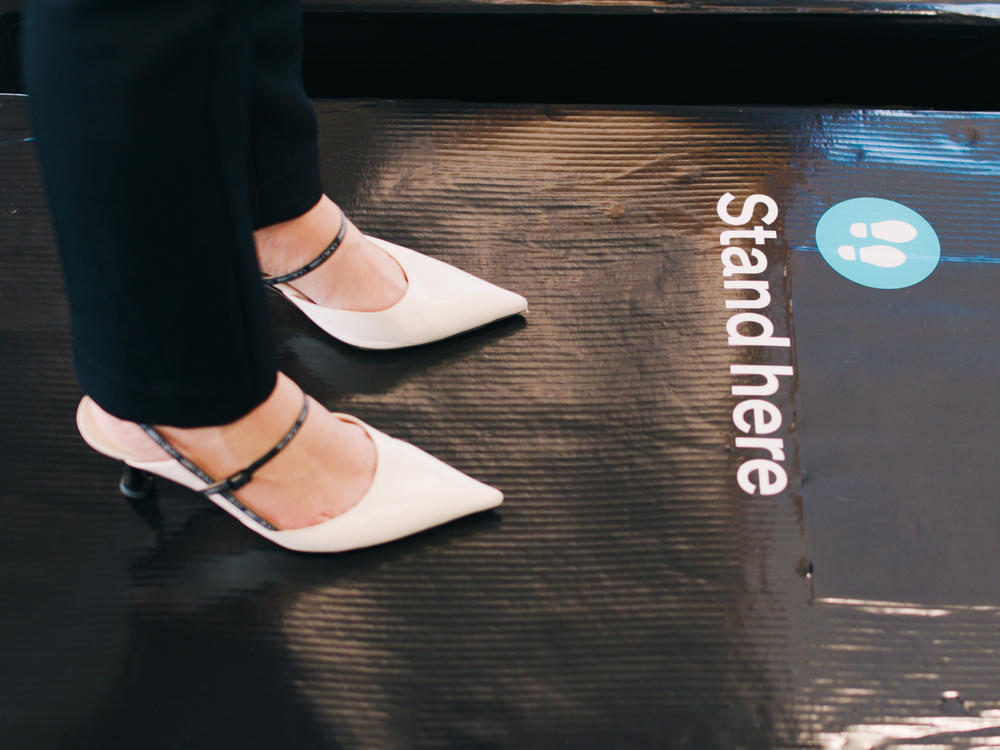 A passenger stands on scales at Auckland International Airport as part of a survey to generate average weights for people traveling on Air New Zealand flights.
