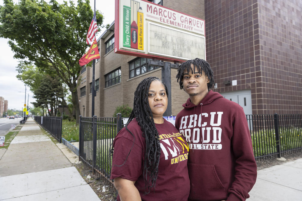 Shoneice Reynolds and her son Asean Johnson stand in front of Marcus Garvey Elementary on the South Side of Chicago. Johnson, who was in third grade when Chicago Public Schools tried to close Garvey, is now a 19-year-old college freshman. The pair fought to keep Garvey open, and it was spared in the 11th hour.