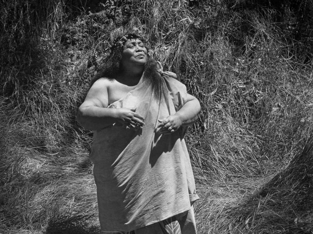 Edith Kanakaʻole chants in the koa forest of Kīpukapuaulu in Hawai'i Volcanoes National Park in 1977. She titled the photo 