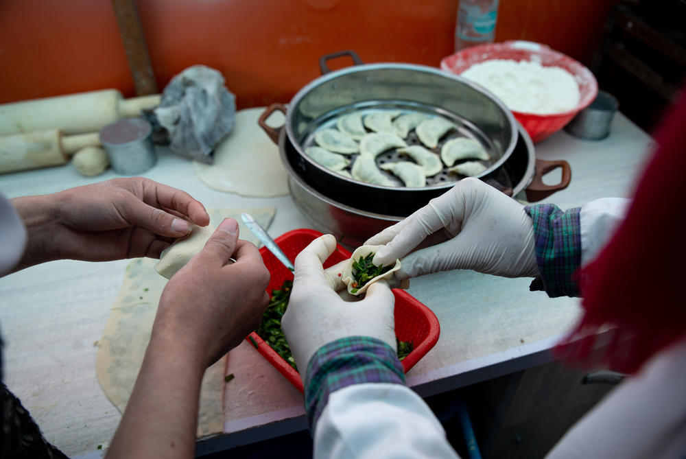 Kitchen staff fill savory pastries at Banowan-e-Afghan.