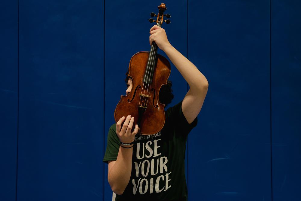A Northern Virginia Juvenile Detention Center resident holds a viola after his final performance in Sound Impact's 