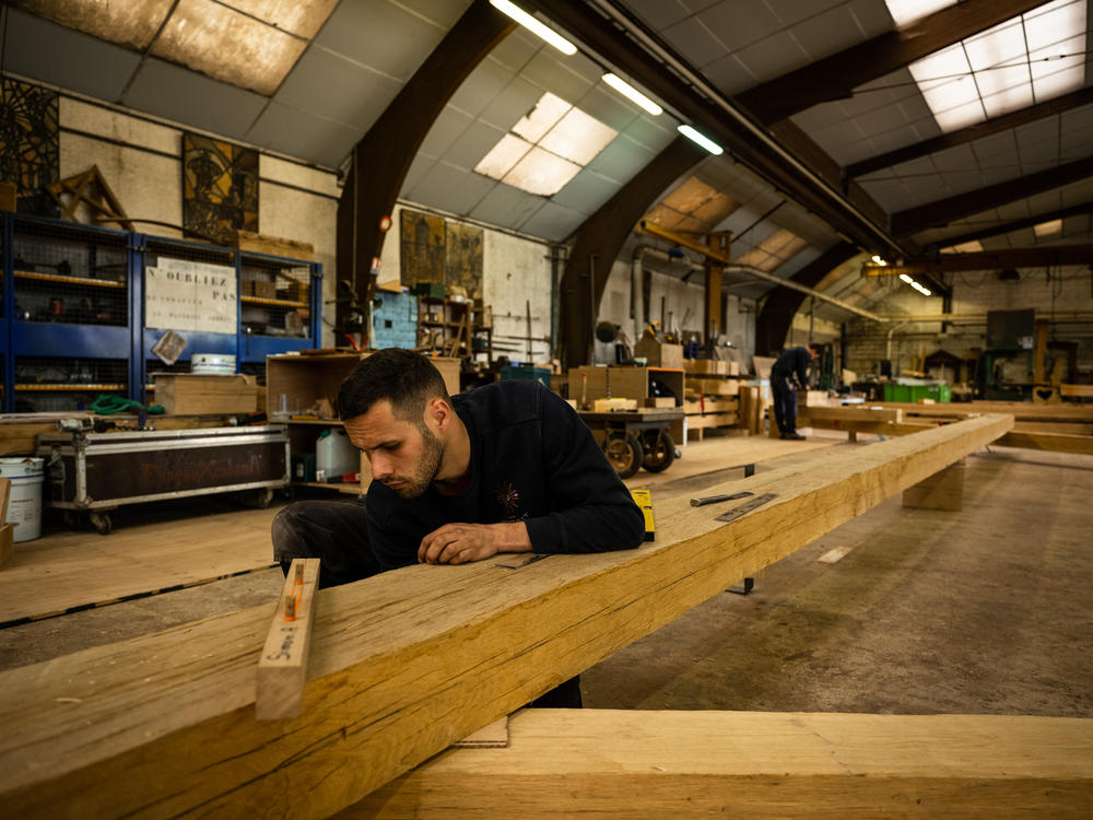 Carpenters work on Notre Dame's trusses, the triangular structures that make up the framework of the cathedral's choir, at the Ateliers Perrault on May 25.