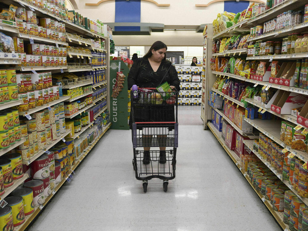 Jaqueline Benitez pushes her cart down an aisle as she shops for groceries at a supermarket in Bellflower, Calif., on Monday, Feb. 13, 2023. Benitez, 21, who works as a preschool teacher, depends on California's SNAP benefits to help pay for food.