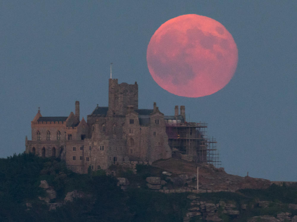 The strawberry moon rises behind St Michael's Mount in Marazion near Penzance on June 28, 2018, in Cornwall, England.