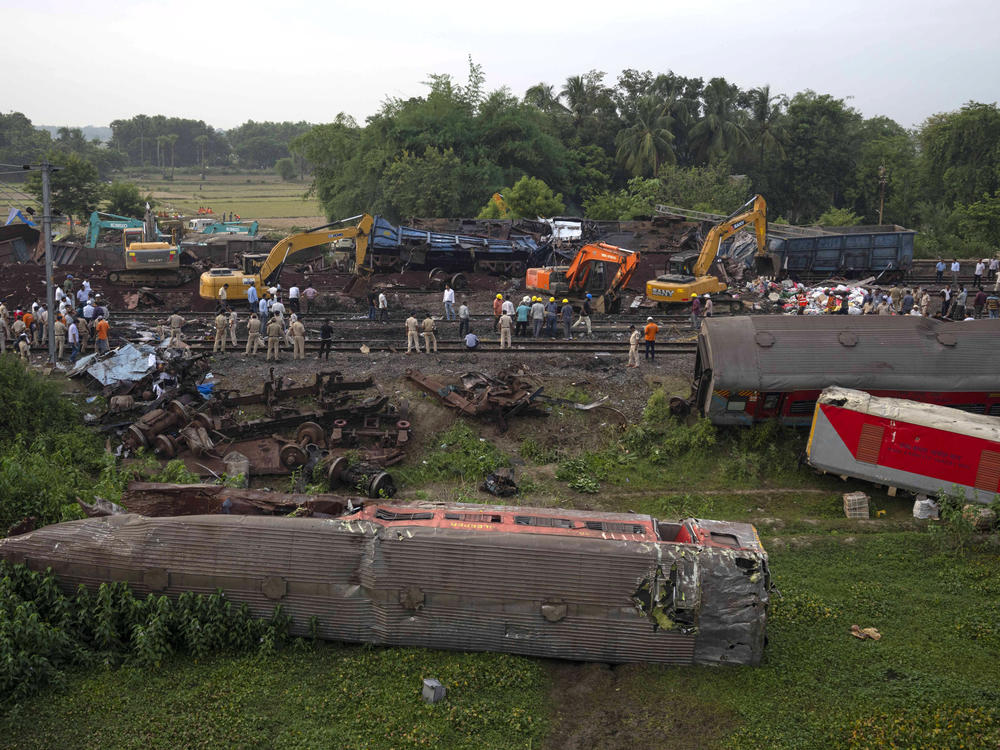 People watch at the site where trains that derailed, in Balasore district, in the eastern Indian state of Orissa, Sunday, June 4, 2023.