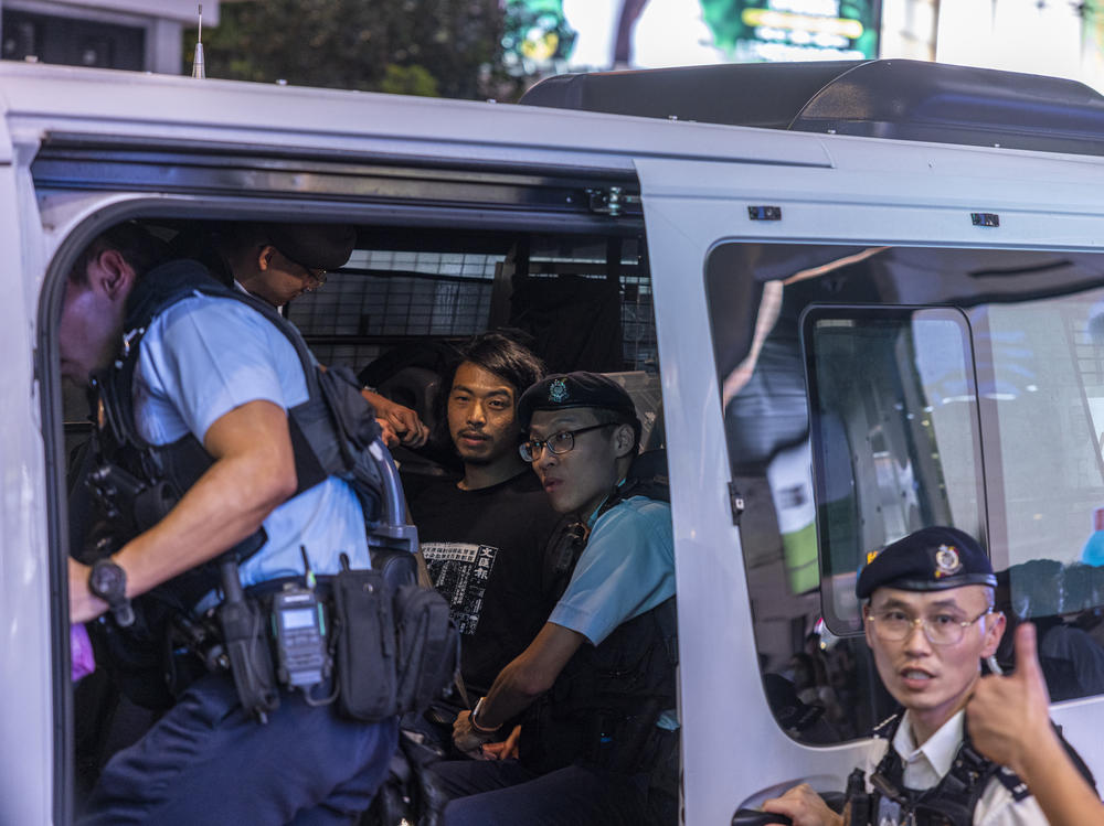 Activist Leo Tang is taken away  on Sunday by police near Hong Kong's Victoria Park, the city's venue for the annual 1989 Tiananmen massacre vigil.