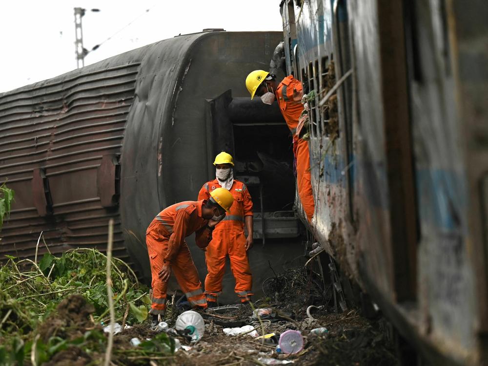 Rescue workers inspect damaged carriages at the accident site of a three-train collision near Balasore on Sunday.