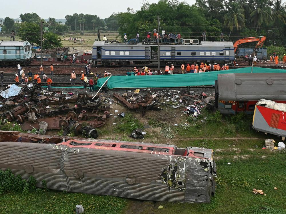 Railway workers help to restore services at the accident site of a three-train collision near Balasore, India, on Sunday.