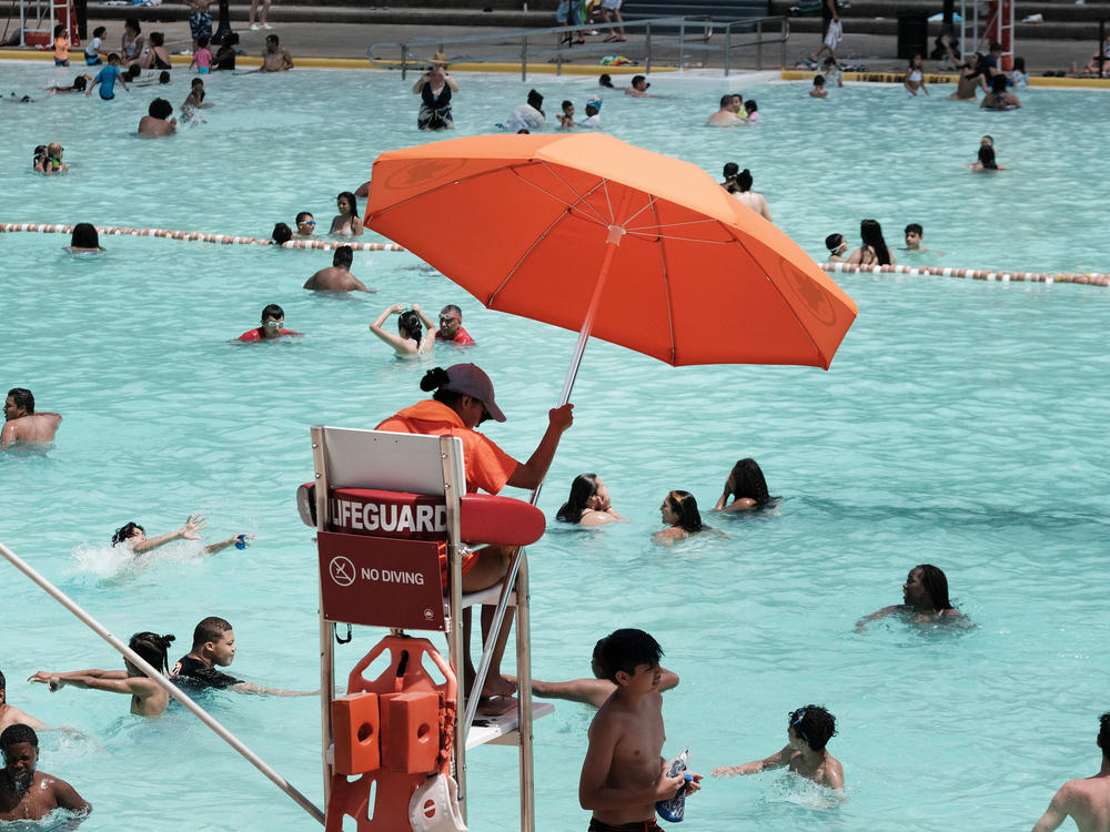 A lifeguard watches as people cool off in a public swimming pool in 2021 in the Astoria neighborhood of Queens in New York City.