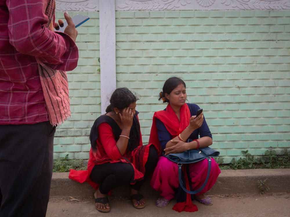 Baisakhi Dhar (left) weeps as she arrives to identify the body of a missing relative kept inside a school on Sunday in Bahanaga village in Balasore district, India.