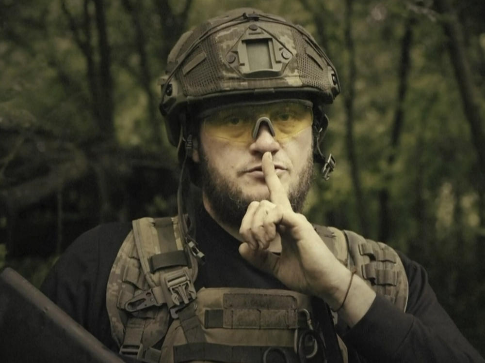 In this image made from video provided by the Ukrainian Defense Ministry on Sunday, a Ukrainian soldier poses for the camera with his finger to his lips. The video shows troops gesturing for silence suggesting that no formal announcement of a possible counteroffensive against Russia will be made. Text appears in the video saying: 