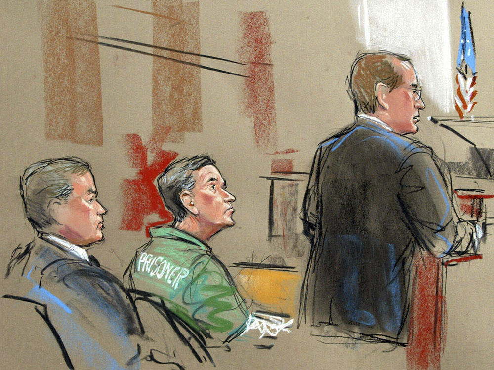 In this artist depiction, U.S. Attorney Randy Bellows, right, addresses the court during the sentencing of convicted spy Robert Hanssen, center, seen with his attorney Plato Cacheris, left, at the federal courthouse in Alexandria, Va., May 10, 2002.