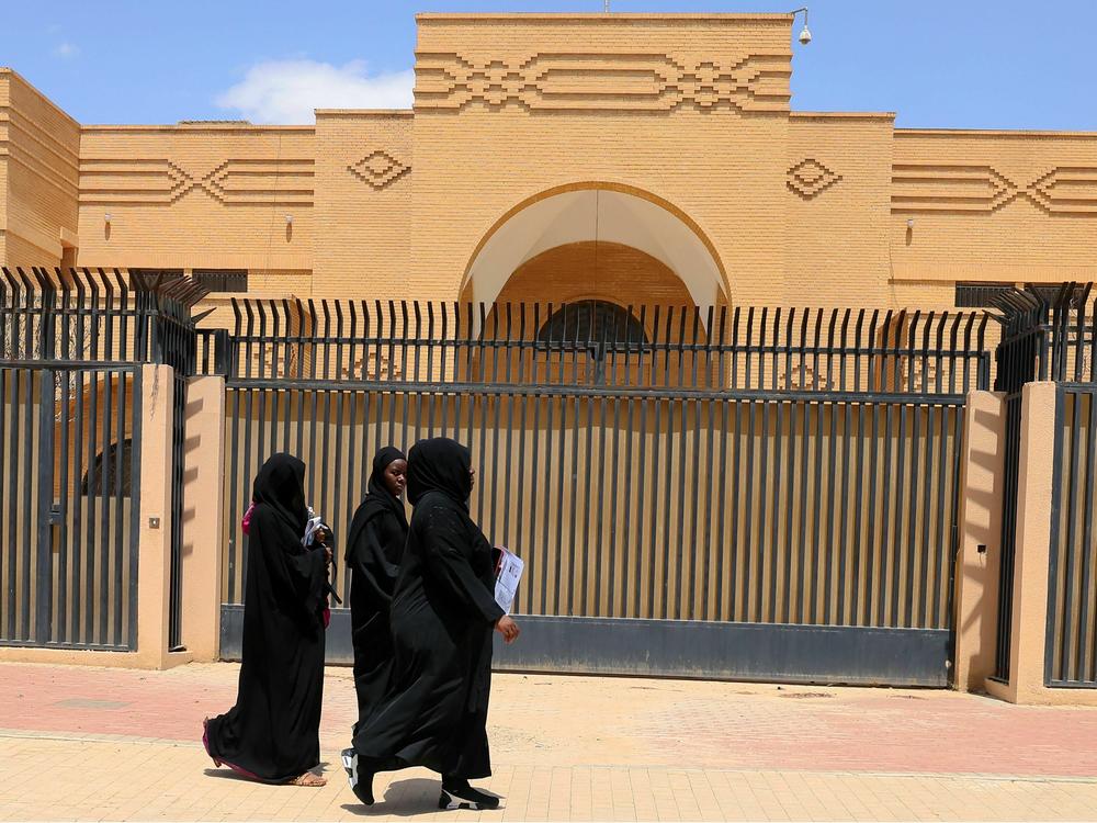 Women walk past the closed Iranian embassy in the diplomatic quarter of the Saudi capital Riyadh, on April 11.