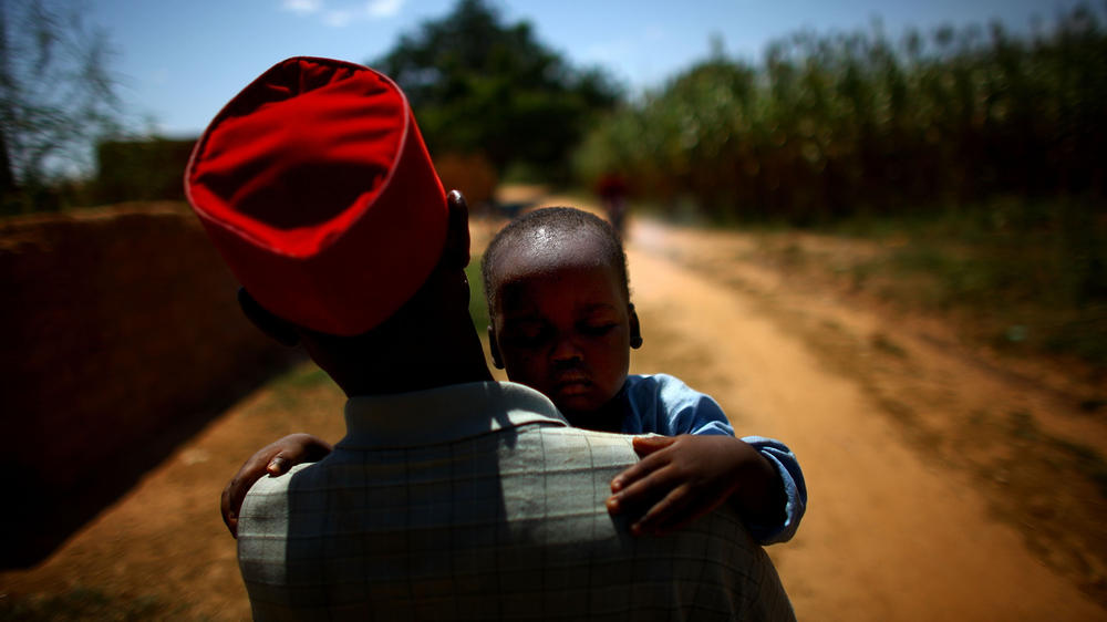 Ado Ibrahim carries his son Aminu through a village in northern Nigeria. Aminu was paralyzed by polio.