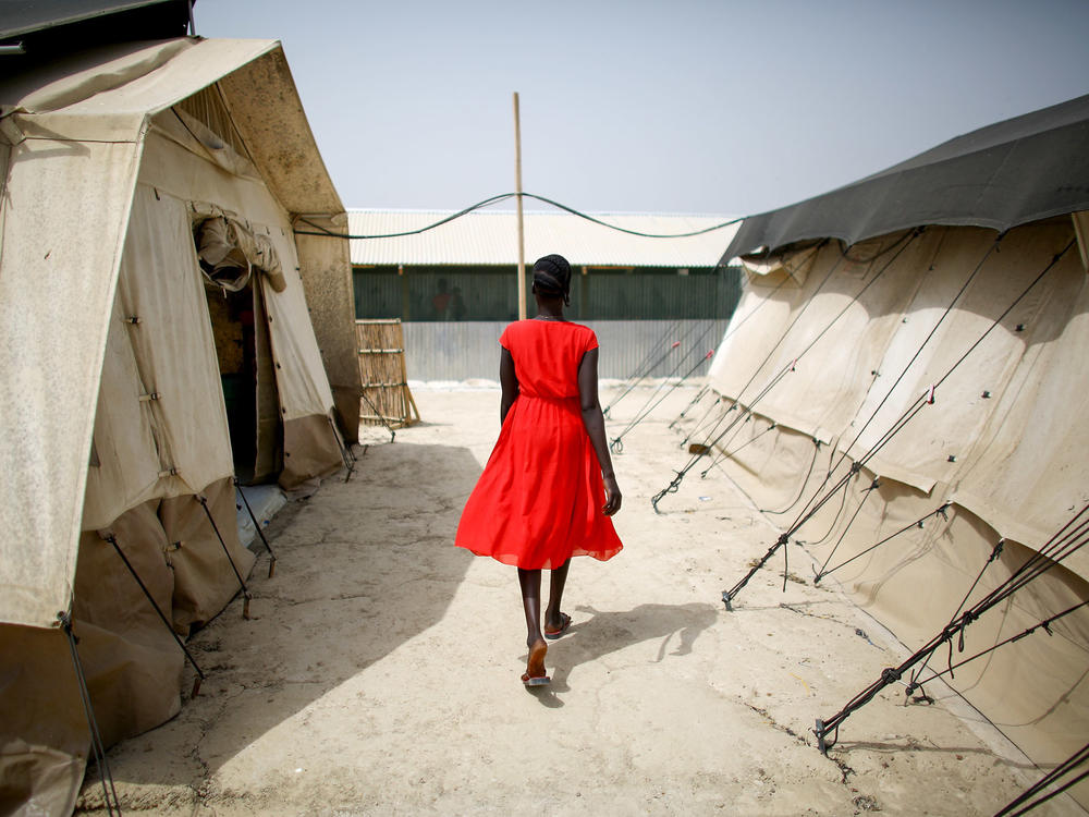 A woman walks between tents that house the hospital wards at a camp for displaced persons in South Sudan. The photo was taken in February.