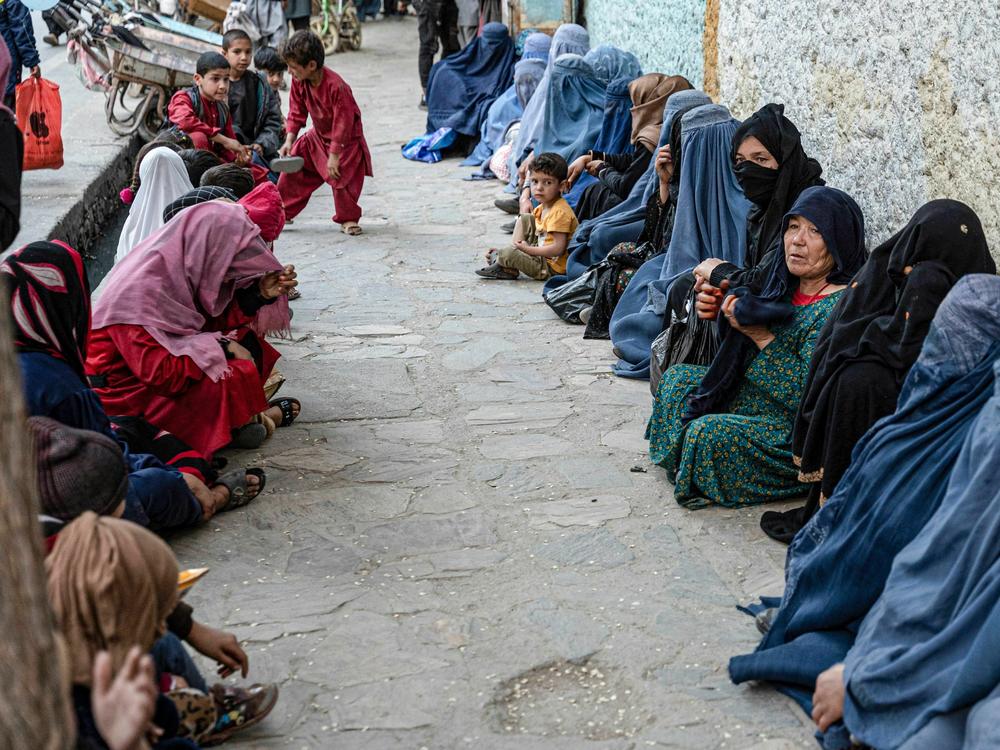 Afghan women wait for a free bread. Charities allege that the Taliban interferes with their distribution of aid by pressuring them to funnel money to the Taliban and its supporters.