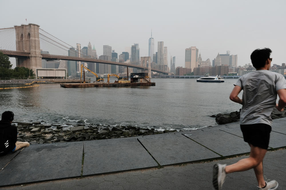 A person jogs through a Brooklyn park on a hazy morning resulting from Canadian wildfires on June 6 in New York City.