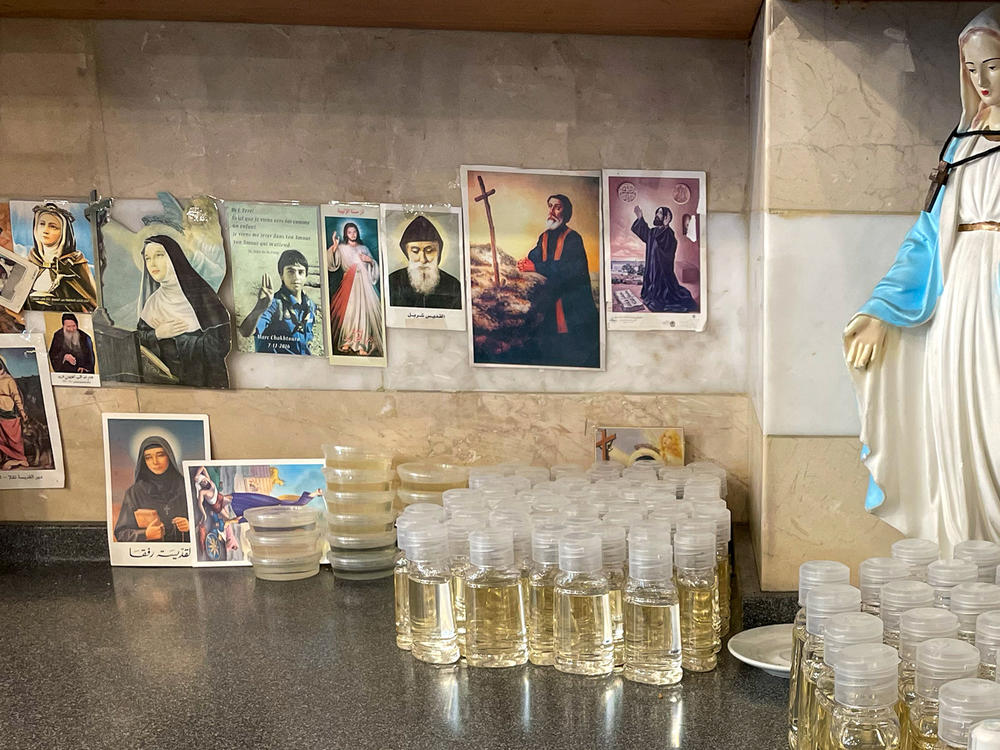 Bottles of sweet syrup infused with rosewater sit alongside Christian saints and figures in one corner of the shop.<a href=