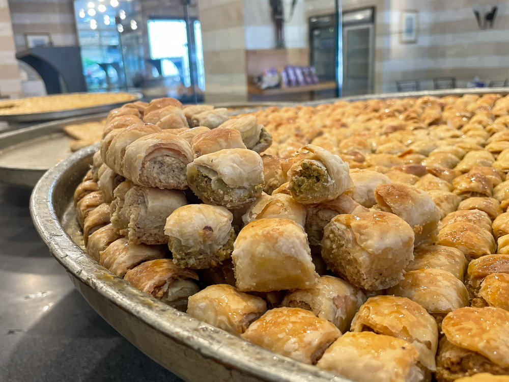 A platter of baklava sits behind the glass, tempting patrons.