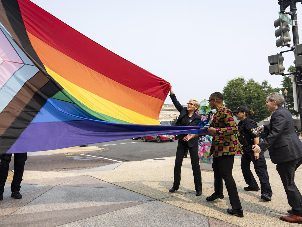 Energy Secretary Jennifer Granholm, center, helps raise a Pride flag outside of the Department of Energy as the Biden administration celebrates Pride Month.