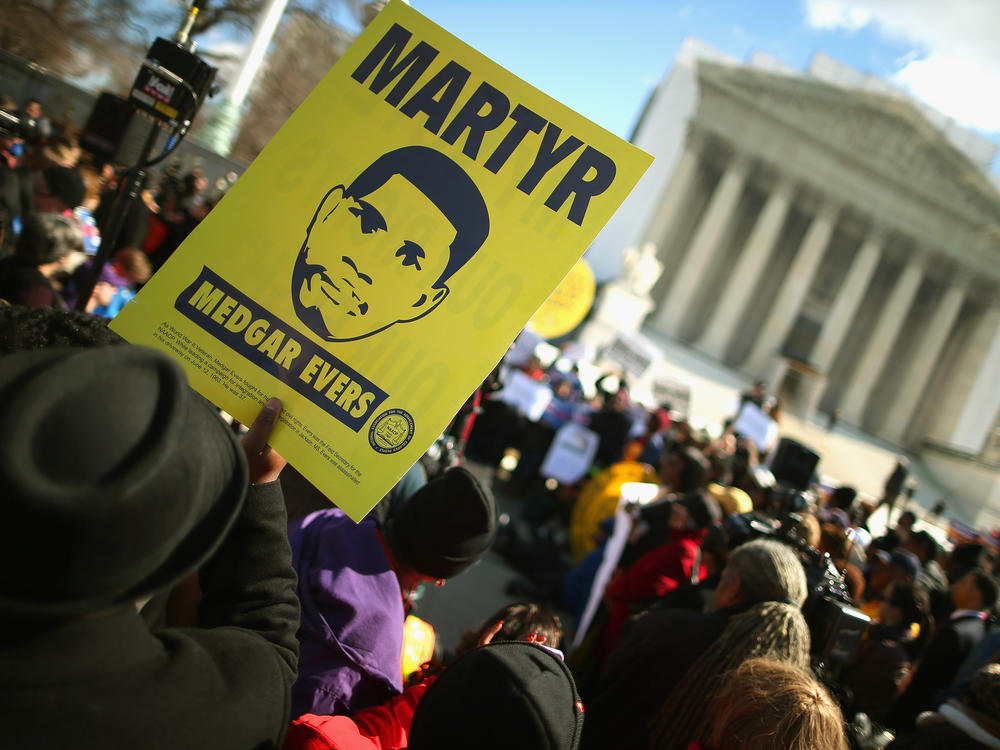 Holding images of Medgar Evers, demonstrators rally in front of the U.S. Supreme Court on Feb. 27, 2013, as it prepared to hear oral arguments in <em>Shelby County v. Holder</em>, a legal challenge to Section 5 of the Voting Rights Act.