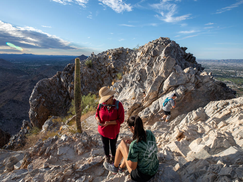 Early morning hikers rest before walking down Piestewa Peak, a city park in Phoenix, Ariz. El Niño drives even hotter, drier weather in the Southwest United States, on top of growing heat risk from human-caused climate change.