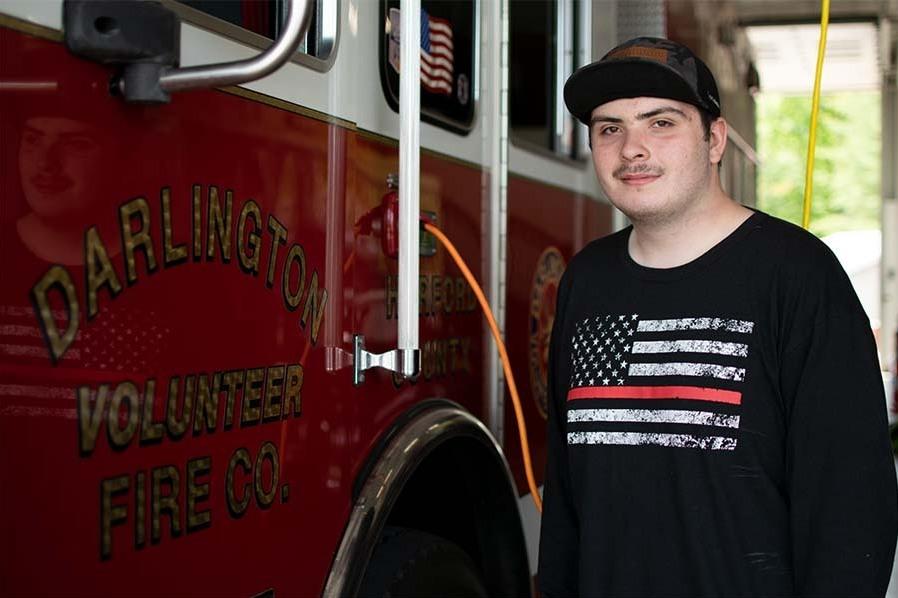 Sam Santelli, 18, stands by a fire engine at Darlington Volunteer Fire Company's fire station 2 in Street, Maryland.