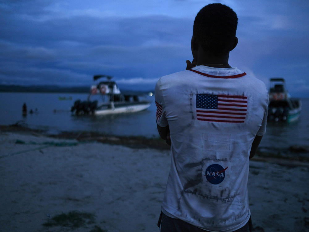 A Venezuelan migrant watches the boat he hopes to take across the Gulf of Urabá once he gets enough money together for the trip.