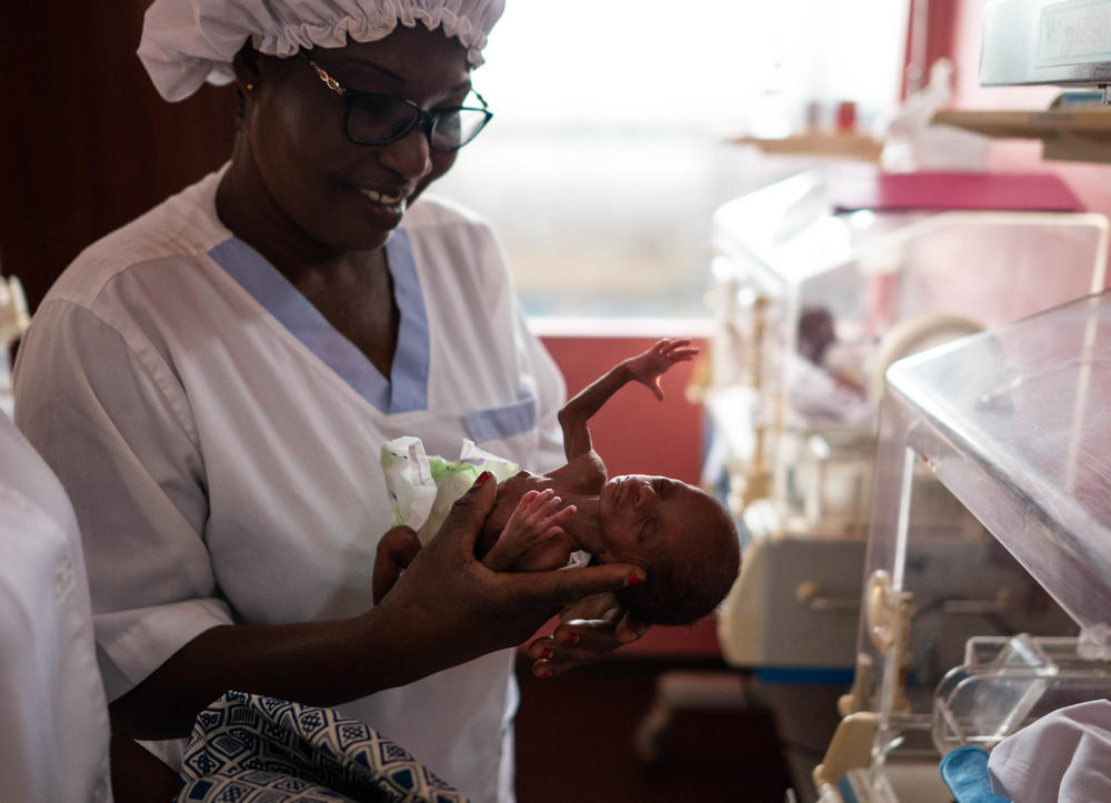 A nurse holds one of Kunoe Zamia's quadruplets — a daughter — as she is placed in incubator in the newborn intensive care unit at the Ivory Coast's University Hospital Medical Center at Treichville. The child's mother is taking a class on kangaroo care in a room next door.