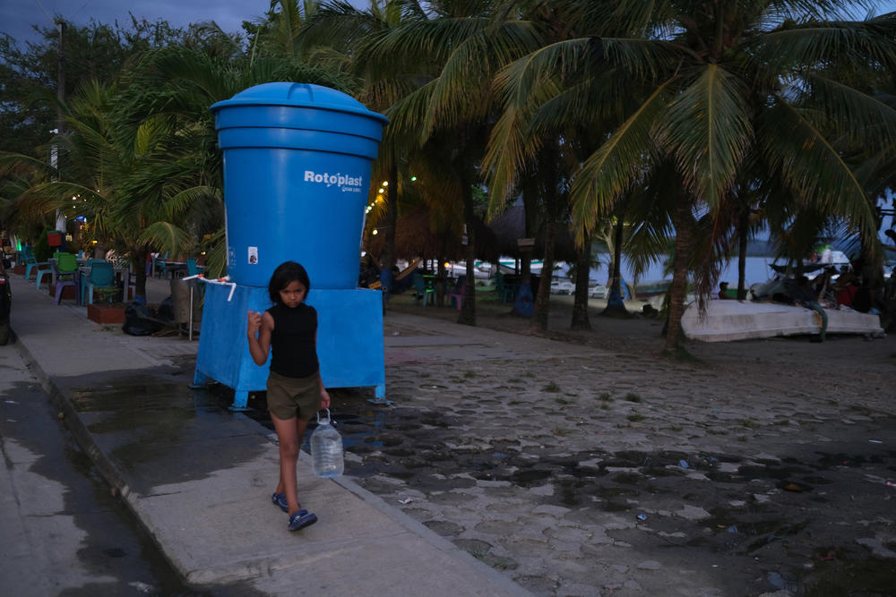 A Venezuelan girl collects water from a fountain in the town of Necoclí.