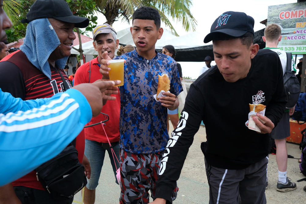 Rafael Guerrero, with a blue towel under his hat, a migrant from the state of Lara, Venezuela, sells empanadas in the town of Necoclí.