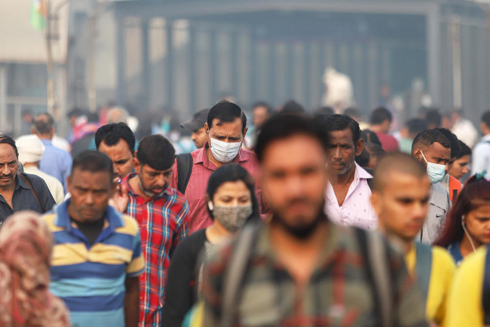 Commuters walk in New Delhi on a smoggy day amid deteriorating air quality levels on Nov. 11, 2022.