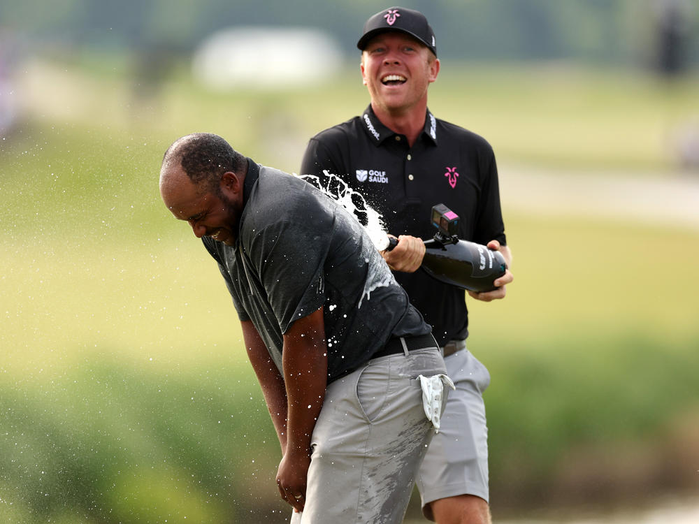 Harold Varner III (left) is doused by teammate Talor Gooch after Varner won the LIV Golf Invitational - DC at Trump National Golf Club on May 28, in Sterling, Va. The upstart tour will be united along with the PGA Tour, in a blockbuster merger.
