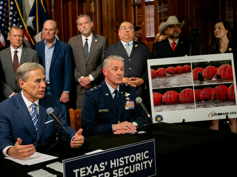 Texas Gov. Greg Abbott (left) speaks about a new border security measure during a news conference at the Texas State Capitol on June 8.