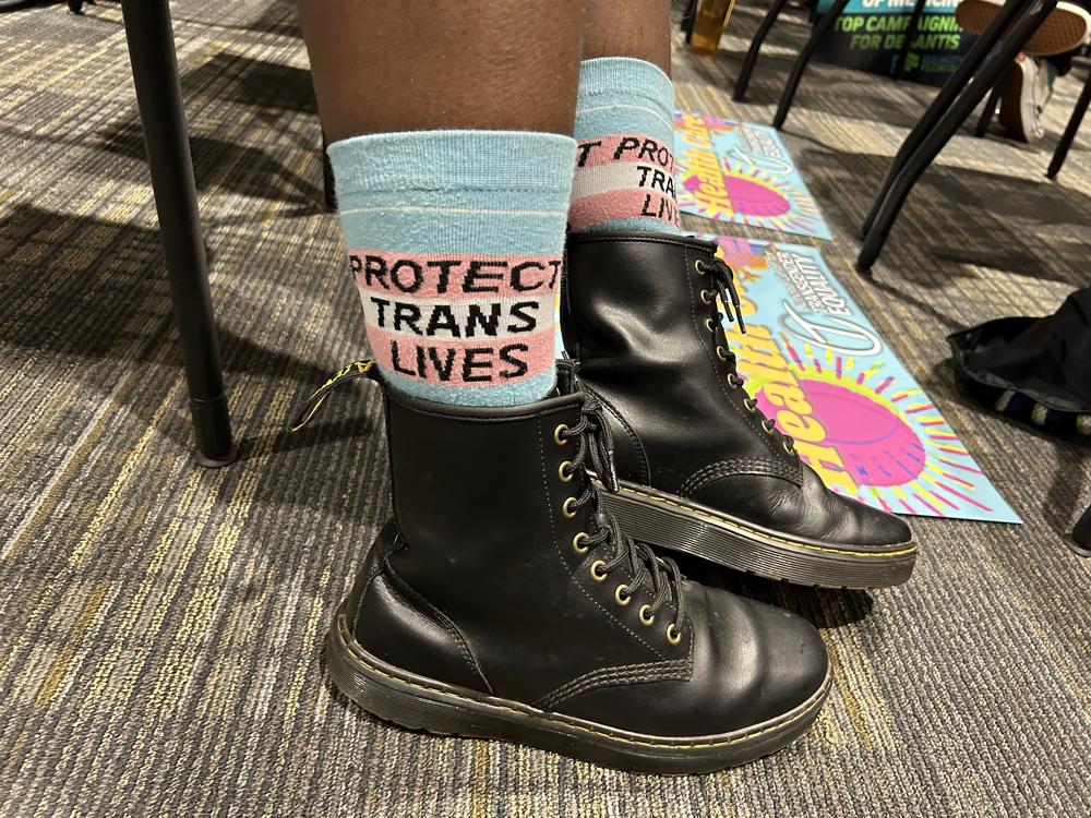 A trans-rights supporter wears socks reading 