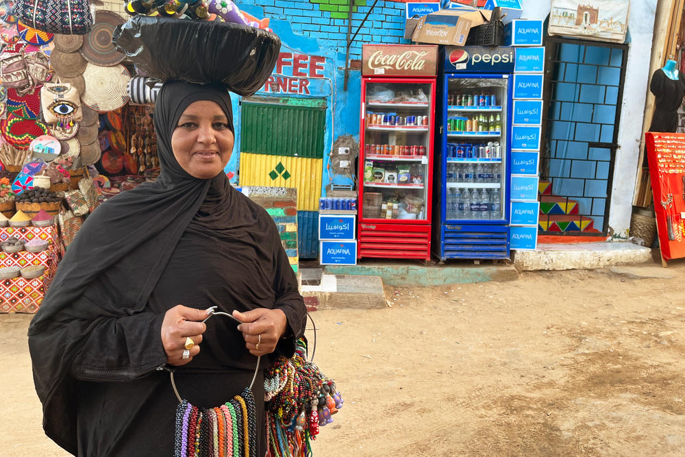 A Nubian woman sells handmade trinkets like beaded bracelets, necklaces and colorful wooden dolls in Aswan, Egypt.