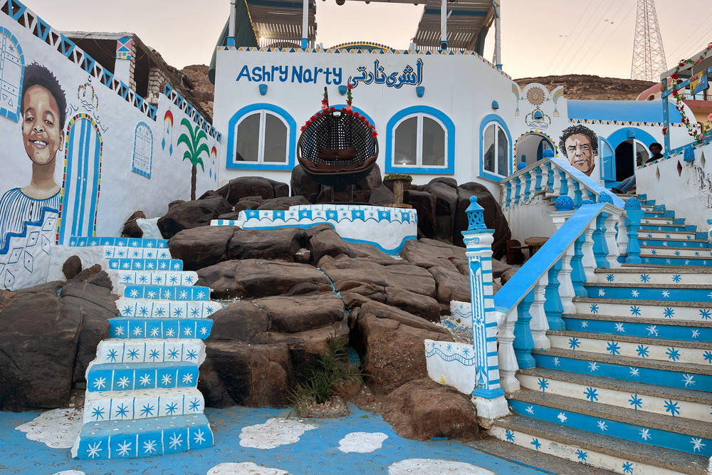 A restaurant in Aswan's Nubian village displays colorful murals depicting Nubian faces and traditional patterns.