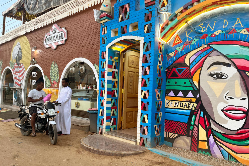 Nubian men stand outside a restaurant in Aswan, Egypt. The walls are painted in bright colors and patterns unique to this region.