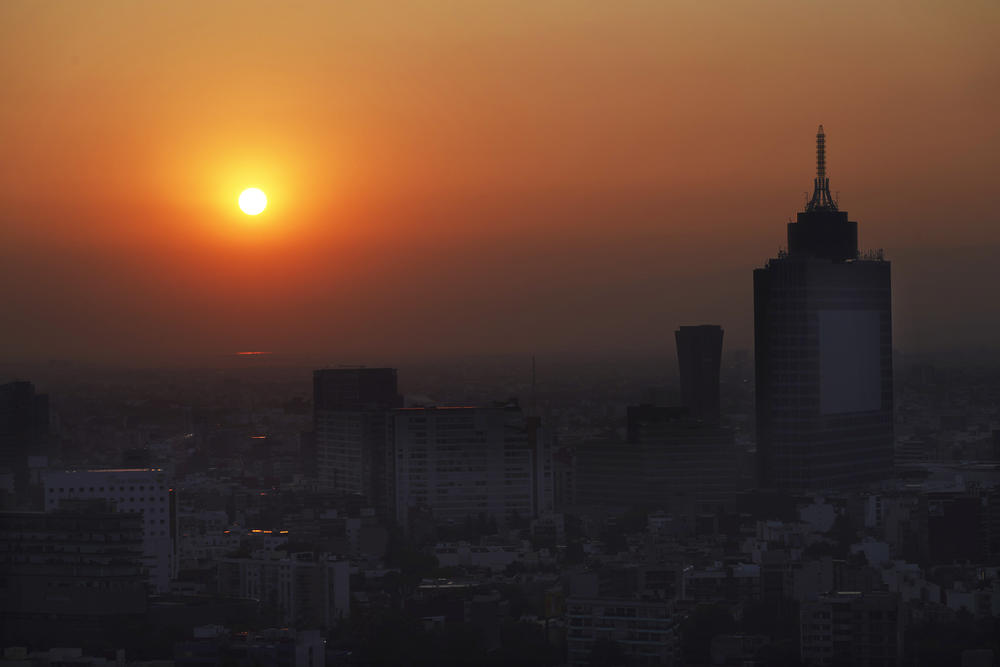The sun rises over Mexico City on a smoggy morning, May 18.