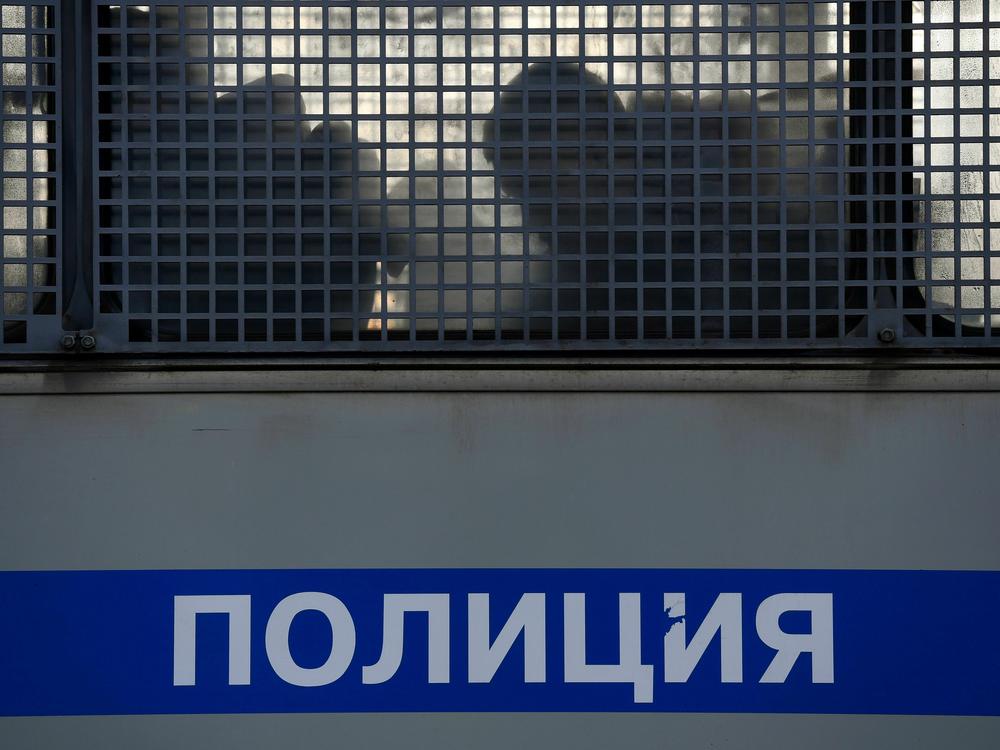 Silhouettes of detained people are seen in a police truck near the Moscow City Court during the trial of a Russian opposition leader in Moscow on February 2, 2021.