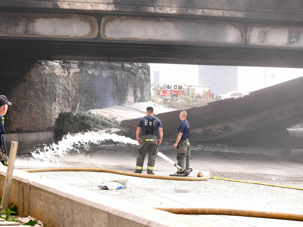 Firefighters work at a collapsed portion of Interstate 95, caused by a large vehicle fire, in Philadelphia on Sunday.