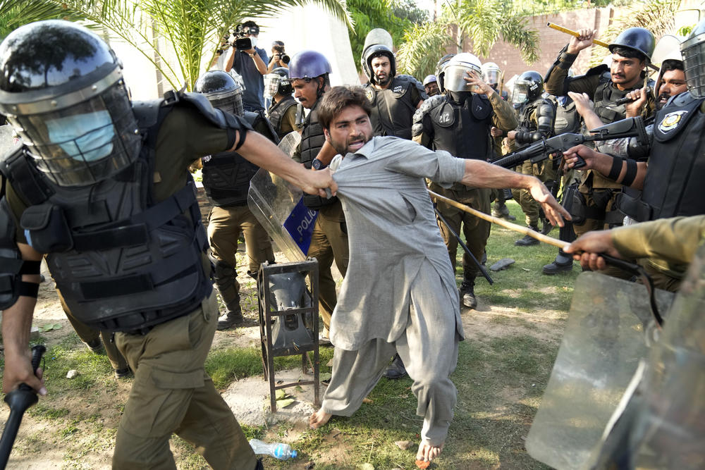 Police detain a supporter of Pakistan's former Prime Minister Imran Khan in Lahore, Pakistan, Wednesday, May 10, 2023.